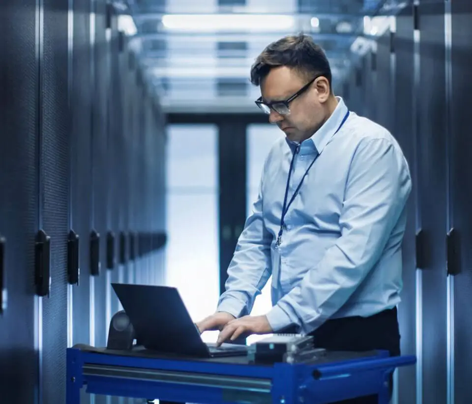 A man standing in front of a laptop computer.